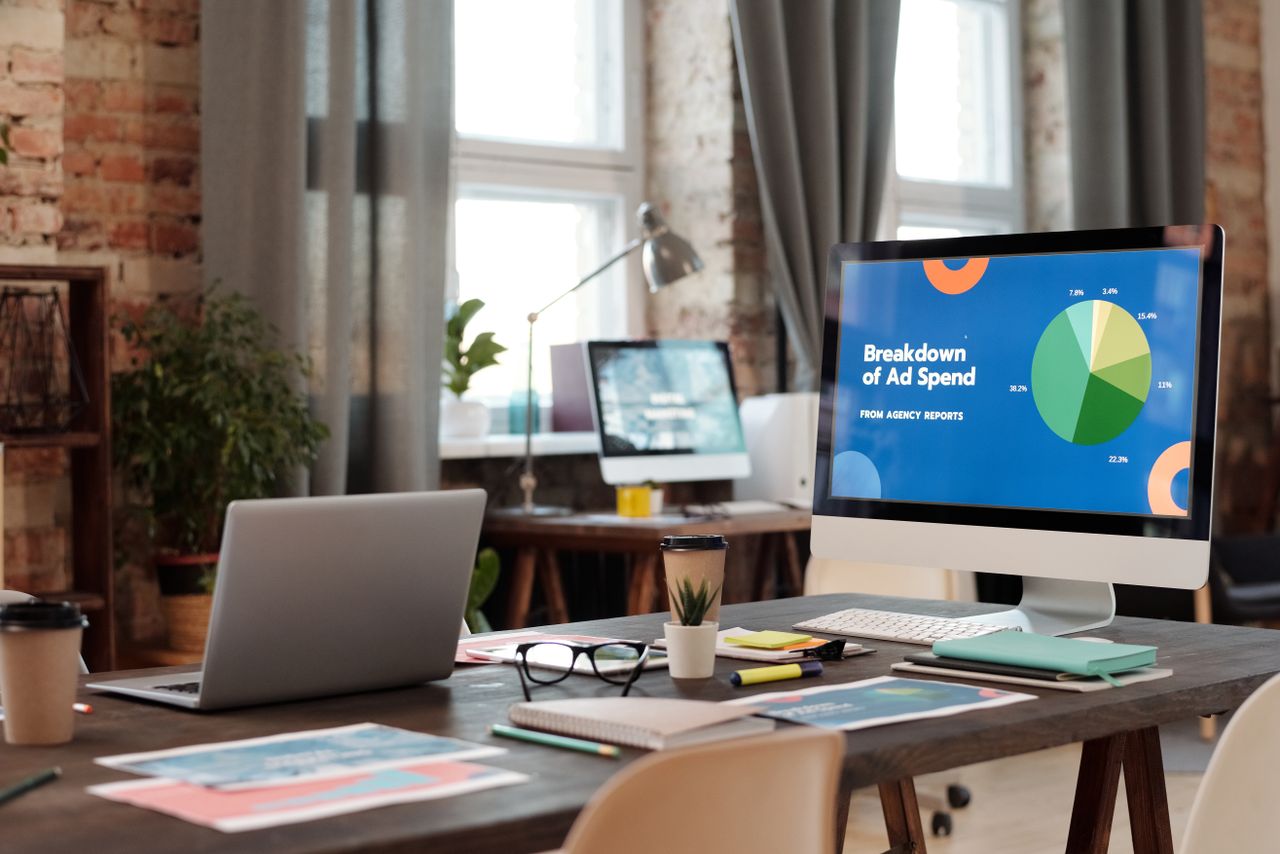 A contemporary office workspace with computers, charts, and office supplies, creating a productive setting.