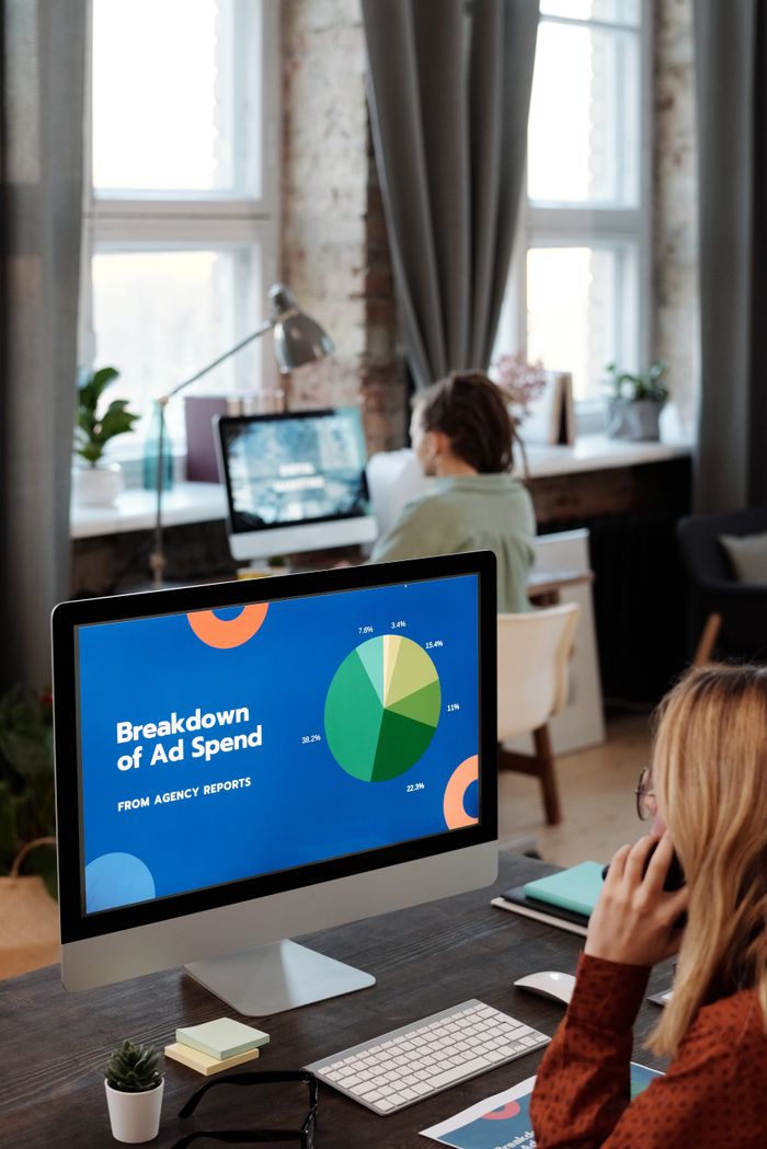 A bright office scene with computers showing data, depicting productivity in a work environment.